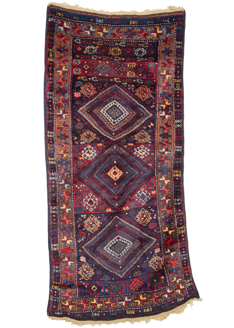 Antique Yoruk rug that features three wonky concentric diamonds each contained within a different color ground and flanked by a strip of pattern repeat on the bottom and five distinct strips of pattern repeat up top. The subtle assymetry gives its personality The whole is framed by a main border of bright polychrome stars on a copper ground. 