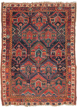 Antique Persian Kurdish Sauj Balug rug featuring staggered rows of "flaming" palmettes that are classic for type. The palmettes alternate in groups of two and three with their serrated edges fitting snuggly together. The rows of three fill the frame whereas the rows of two are filled with various random protection symbols. The navy ground transitions to brown near the bottom quadrant. Framed by interesting and varied borders of running water, "S" filled cartouches and tulips going from inner to outer.