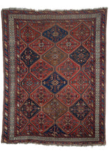 Afshar rug handwoven at the turn of the twentieth century in Southwest Iran. All over geometric pattern of lozenges filled with intricate geometric designs. Color palette of red, blues and ivory with pops of light brown and yellow. 