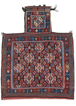 Antique Afshar salt bag featuring a soumak woven face with a satisfying repeat field pattern of small diamonds and diagonal striped orbs composed of smaller geometric shapes. The pattern is simple yet complex with bright, blues reds and oranges playing off the strong contrast of black and white.  It is framed by a border of alternating X's and diamonds reminiscent of the classical egg and dart motif. The neck has a single orb with it's own personal "x" and diamond border. 