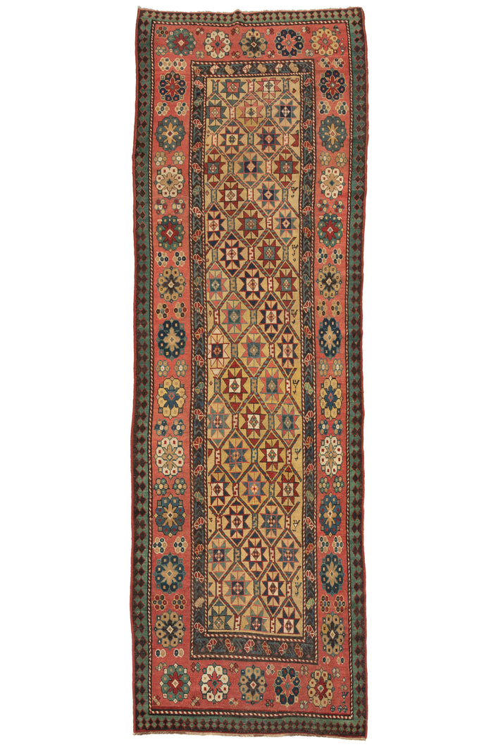 This Yellow Shirvan Runner features lattice-filled eight-pointed stars on a rare and desirable yellow ground. The stars are laid out in diagonal columns which are rendered in rich reds and blues and green jewel tones. It is framed by a main border of both small and large Talish rosettes on a salmon ground with an inner border of carnations and an outer laleh abbasi guard border in contrasting tones of turquoise and chocolate.