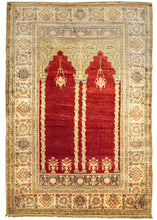 This Large Silk Kayseri Rug features a double niche mihrab with four columns, two hanging lanterns, and four potted plants. It has a very architectural feel as though looking into a mosque. The arches atop the columns have intricate foliage like that which would grow on the side of a building. The blood-red ground is very striking and pops against the soft and subtle tones of green, yellow, pink, blue, and beige. 