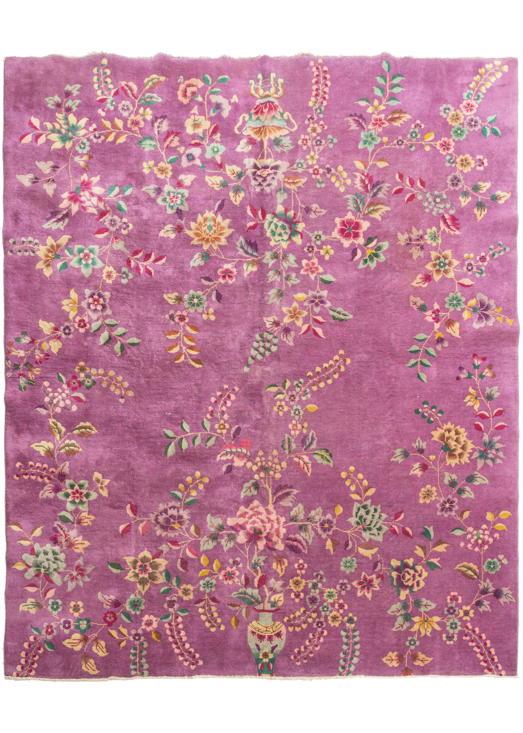 Chinese purple pink deco featurinng truly unique light purple field. The design is open and borderless, and is composed of large-scale floral motifs like sprays, vines, and tendrils growing from vases at either ends of the rug. Notice the stippling and color variation, beautifully rendered by the weaver. The accenting palette is composed of greens, pinks, and golden yellows. 