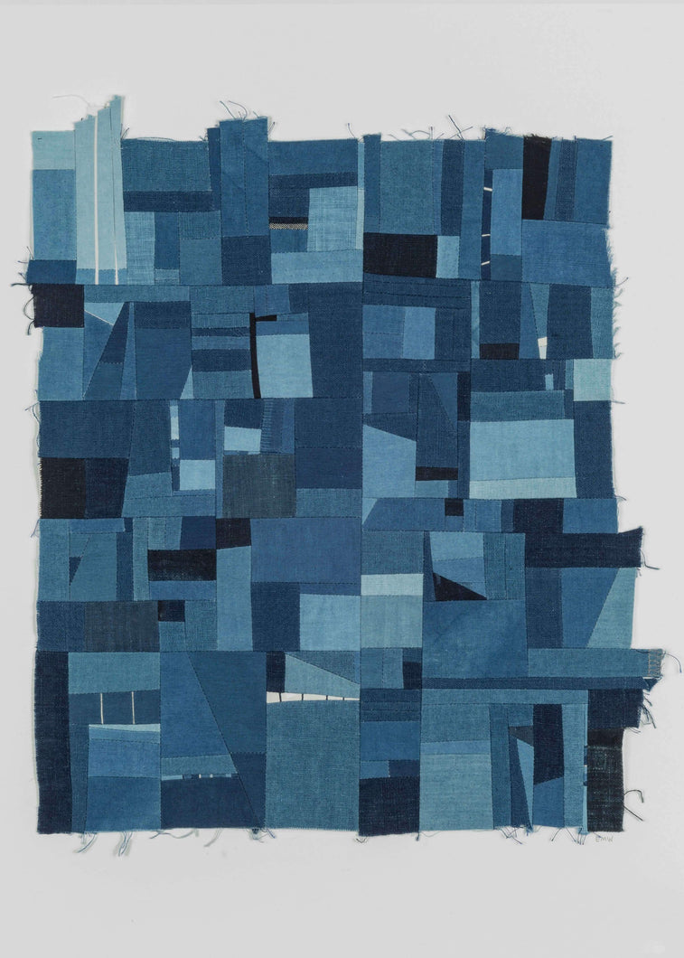 Erin Wilson quilt entitled Indigo Assembly 5 featuring a limited color palette of varying shades of indigo with small sections of white dispersed throughout to add a lightness to the piece. Most of the sections are either square or rectangular, but there are a few triangle like shapes spread throughout, disrupting the grid. The outer shape of this piece is asymmetrical and features raw edges. 