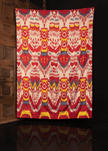 Silk ikat handmade in Uzbekistan. Silk front features a repeating abstract motif in yellow, red, blue and white atop a white field. 