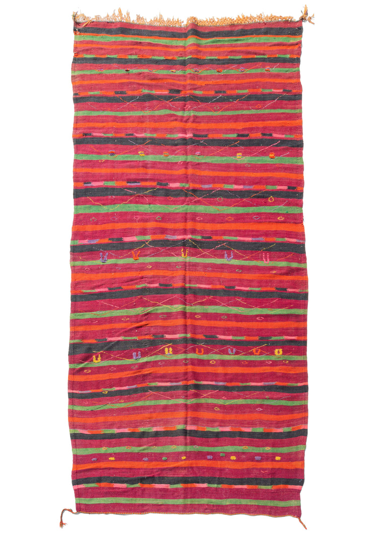 Mid century Moroccan Boujad kilim featuring various stripes with red, orange, bright pinks, highlighter yellow purples and lime green. Colorful diamonds and other protection symbols are embellished over the top.