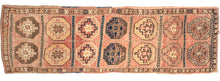 This Mid Century Kars Runner features features a large grid full of fun and wonky memling guls in reds, browns, yellows, and navy on the faded coral ground.  The field is framed by a simple thin brown border and the edges have been finished with multiple selvages.