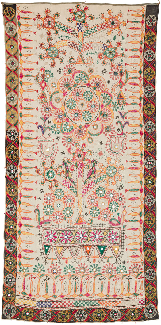 Mid century Kutch Dharaniya Embroidery featuring a free-hand design of trees, birds, and rosettes, embroidered in a rainbow of colors alongside lovely mirror-work. We find yellows, oranges, greens, and pinks, on a soft ivory ground. The border is black with mirror-work embroidery resembling suns.