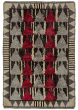 This Mid Century Rya Rug features a geometric design in black, white, red, and both gray and silver. The field is composed of alternating columns of red and silver triangles each stacked seven high against a ground of black and white wandering stripes. It is framed by a pattern of gray triangles and hash marks on a white ground. The geometric design mixed with the long shaggy pile gives a very modern feel.   In very good condition with minimal wear. Pile is shaggy, the handle is heavy but soft. 