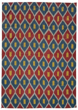 Silk Uzbek handwoven ikat textile featuring a repeating interlocking diamond motif in blue, red, and yellow with a white outline. The back is a brightly colored paisley print on synthetic fabric. 