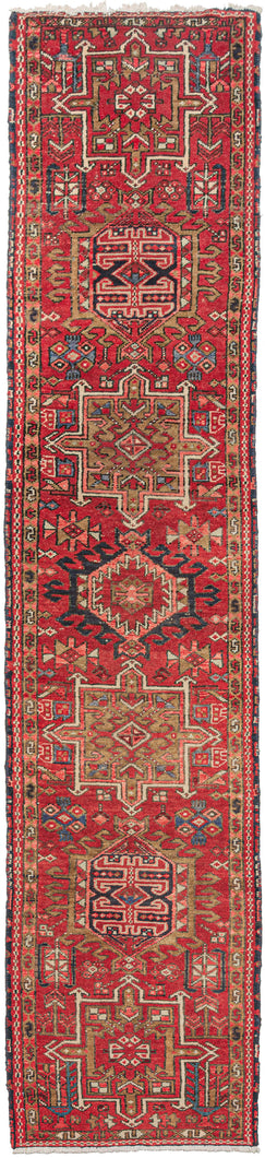 Vintage Karaja runner featuring a pattern of alternating geometric shapes and hooked lozenges on a rich red ground. Indigo blues, charcoal, gold, pink, and ivory provide a well-balanced palette. In a desirable narrow format of only ~2' wide format 