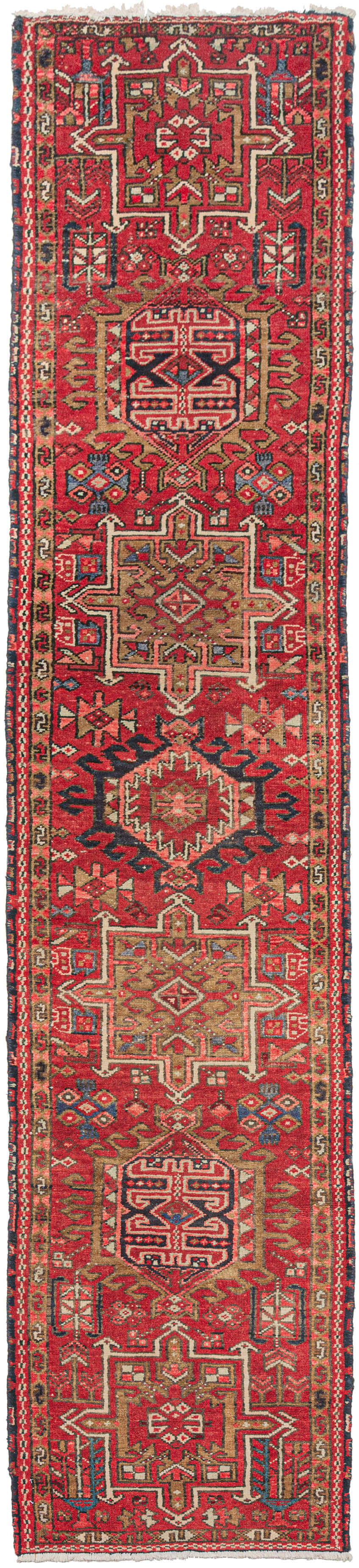 Vintage Karaja runner featuring a pattern of alternating geometric shapes and hooked lozenges on a rich red ground. Indigo blues, charcoal, gold, pink, and ivory provide a well-balanced palette. In a desirable narrow format of only ~2' wide format 