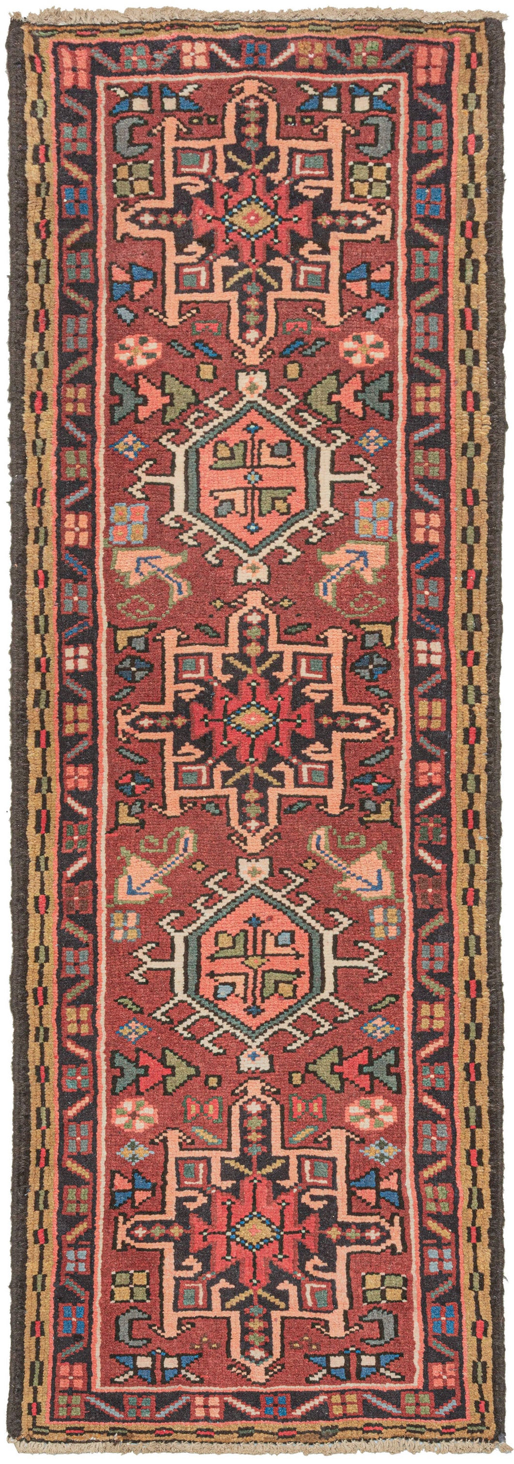 Vintage small Karaja runner featuring a pattern of alternating geometric shapes and hooked lozenges on a red ground. Blues, green, charcoal, gold, pink, and ivory provide a well-balanced palette. In a rare narrow and short runner format.