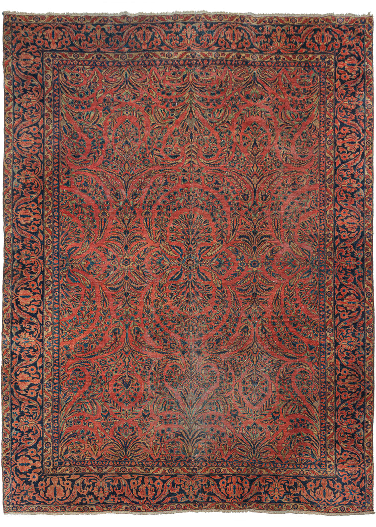 Dynamic Red Sarouk Rug features a curvilinear floral design on a patinated red field. The floral work is intricate and an excellent example of the type of floral sprays Sarouk rugs are known for. The main border features scrolling palmettes on navy ground.