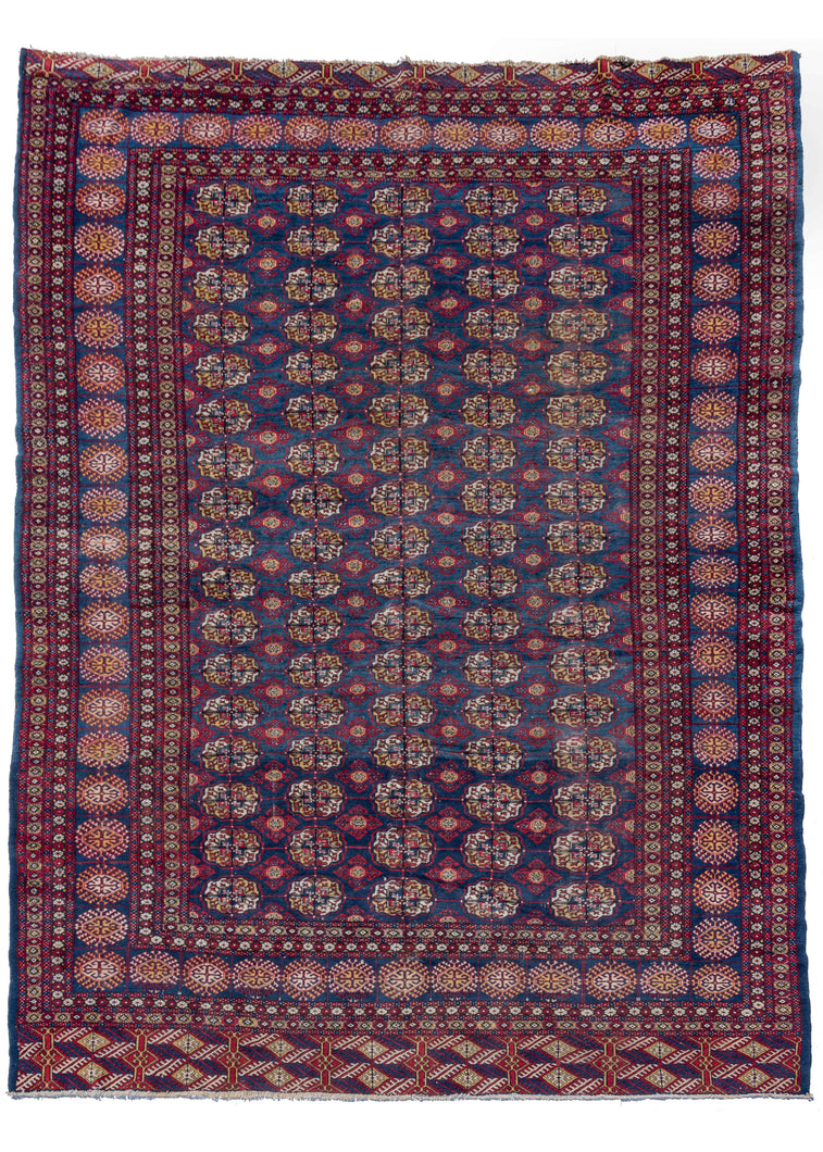 Vibrant Bokhara rug composed of a strong red and blue color palette with accents in orange, yellow and ivory. Woven in Pakistan by Afghan refugees in the 1980s, the pattern is a classic gül design, a clear evolution from classic Turkmen rugs.